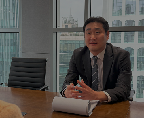 회의실 테이블에서 설명하는 정장 차림 사람