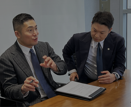 서류를 펼쳐 두고 대화하는 두 사람