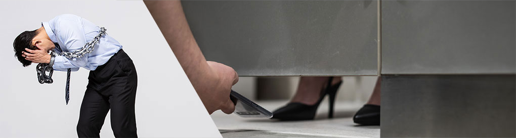 고개 숙인 사람과 칸막이 아래 스마트폰